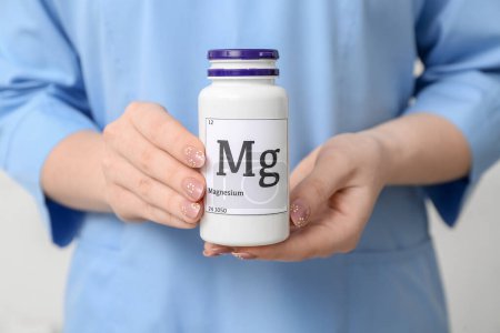 Foto de Doctora sosteniendo la botella de píldoras de magnesio, primer plano - Imagen libre de derechos