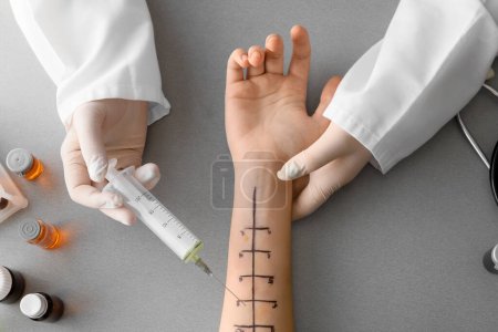 Téléchargez les photos : Médecin avec seringue et main marquée du patient pour les tests cutanés d'allergie sur fond gris - en image libre de droit