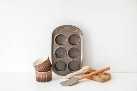 Foto de Set de utensilios de cocina con bandeja para hornear sobre fondo claro - Imagen libre de derechos