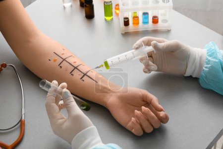 Foto de Médico con jeringa haciendo prueba cutánea de alergia en la mano del paciente en la clínica, primer plano - Imagen libre de derechos