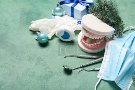 Zahnarztwerkzeuge mit Weihnachtsdekor auf grünem Hintergrund