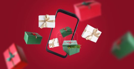 Téléchargez les photos : Téléphone portable volant avec cadeaux sur fond rouge - en image libre de droit