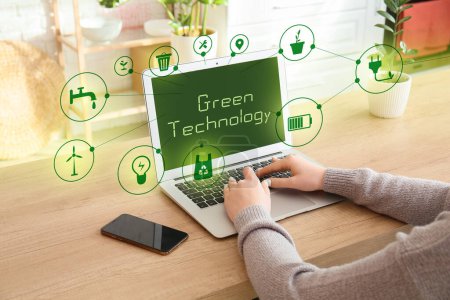 Woman using laptop in office. Green technology concept