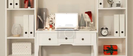 Téléchargez les photos : Lieu de travail moderne avec ordinateur portable et décor de Noël dans le bureau léger - en image libre de droit
