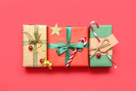 Téléchargez les photos : Beaux cadeaux de Noël sur fond rouge - en image libre de droit