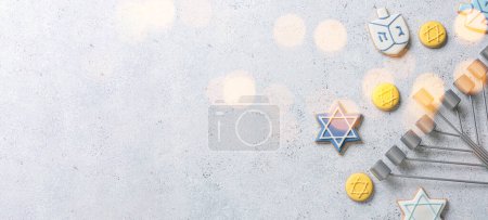 Menorah and cookies for Hanukkah celebration on light background with space for text
