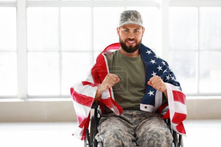 Téléchargez les photos : Jeune soldat en fauteuil roulant avec drapeau américain à la maison - en image libre de droit