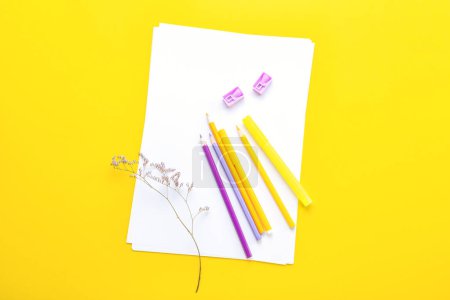 Téléchargez les photos : Feuille de papier vierge avec crayons, feutres, aiguiseurs et fleurs sur fond jaune - en image libre de droit