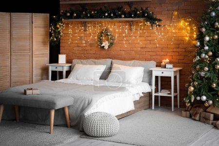 Photo for Interior of bedroom with Christmas branches, fir tree and glowing lights - Royalty Free Image