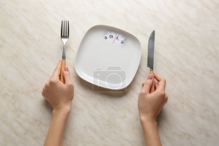 Photo for Female hands with empty plate and cutlery on light background. Diet concept - Royalty Free Image