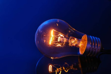 Photo for Glowing light bulb on dark color background - Royalty Free Image