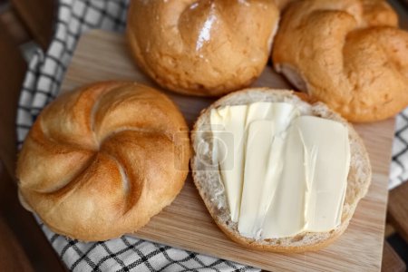 Photo for Delicious kaiser rolls with butter on wooden board - Royalty Free Image