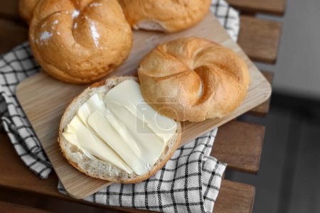 Photo for Delicious kaiser rolls with butter on wooden board - Royalty Free Image
