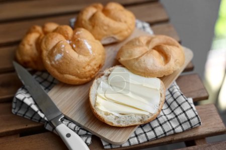Photo for Kaiser rolls with butter on wooden board - Royalty Free Image