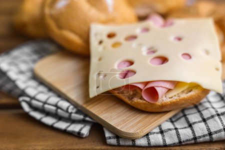 Photo for Delicious kaiser rolls with ham and cheese on wooden board - Royalty Free Image