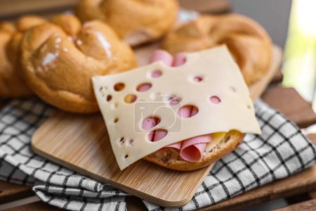 Photo for Delicious kaiser rolls with ham and cheese on wooden board - Royalty Free Image
