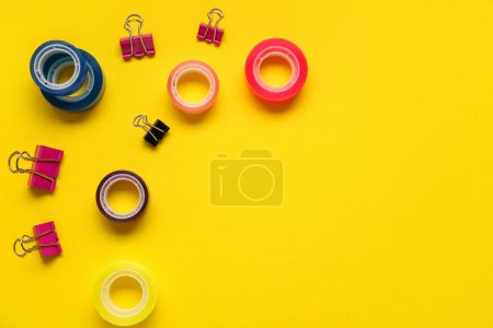 Foto de Composición con clips y cintas adhesivas sobre fondo amarillo - Imagen libre de derechos