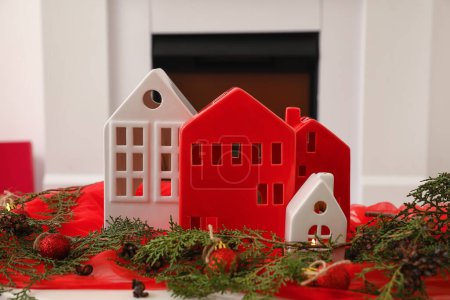 Téléchargez les photos : Bougeoirs en forme de maison avec boules de Noël et branches de conifères sur la table dans la chambre, gros plan - en image libre de droit