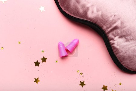 Foto de Tapones para los oídos y máscara para dormir sobre fondo rosa - Imagen libre de derechos