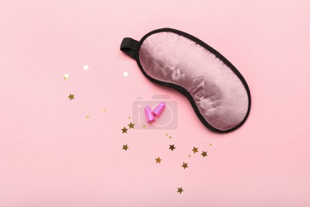 Téléchargez les photos : Bouchons d'oreilles et masque de couchage sur fond rose - en image libre de droit