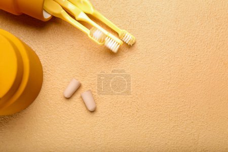 Téléchargez les photos : Bouchons d'oreilles en mousse et brosses à dents sur fond de couleur - en image libre de droit