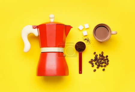 Foto de Cafetera géiser, taza de café, cuchara y frijoles sobre fondo amarillo - Imagen libre de derechos