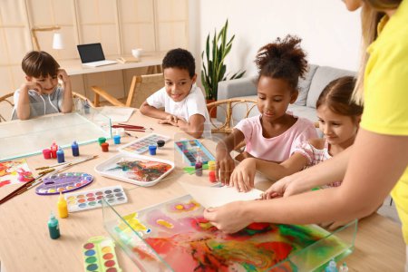 Téléchargez les photos : Petits enfants avec professeur papier marbré en atelier pour la peinture Ebru - en image libre de droit