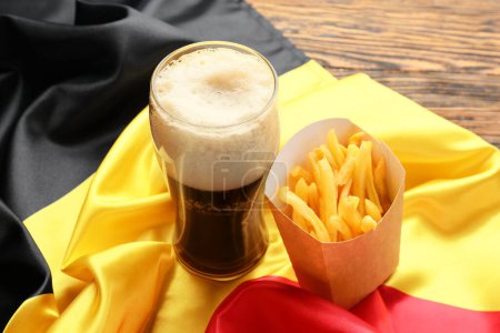 Téléchargez les photos : Drapeau de Belgique, verre de bière et boîte en papier avec frites sur fond bois, gros plan - en image libre de droit