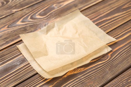 Foto de Hojas de papel para hornear sobre fondo de madera - Imagen libre de derechos