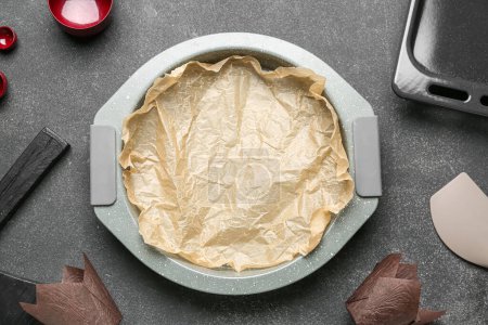 Photo for Baking dish with paper and different utensils on grey background - Royalty Free Image
