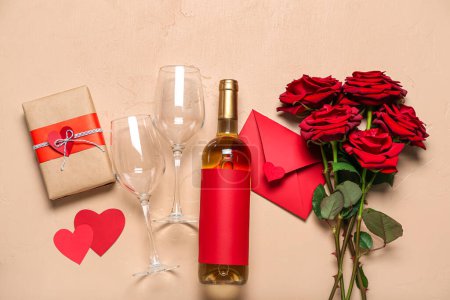 Foto de Botella de vino, vasos, sobre, regalo y rosas sobre fondo beige. Celebración de San Valentín - Imagen libre de derechos
