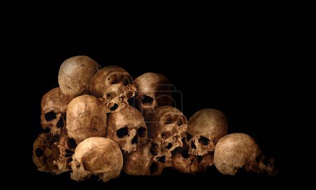 Foto de Muchos cráneos humanos viejos sobre fondo negro - Imagen libre de derechos