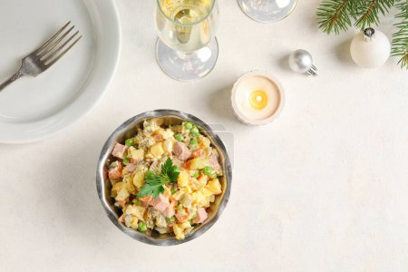 Photo for Bowl of tasty Olivier salad, burning candle and glass of champagne on light background - Royalty Free Image