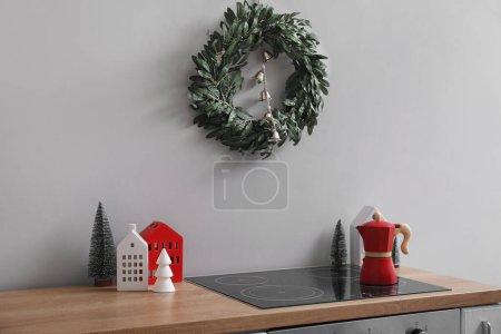 Téléchargez les photos : Couronne de Noël suspendue au mur gris dans la cuisine - en image libre de droit
