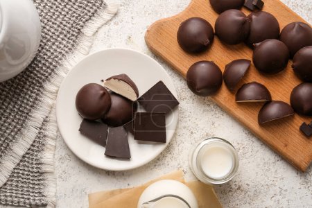 Téléchargez les photos : Assiettes avec bonbons au lait d'oiseau au chocolat doux et cruches de lait sur la table de cuisine - en image libre de droit