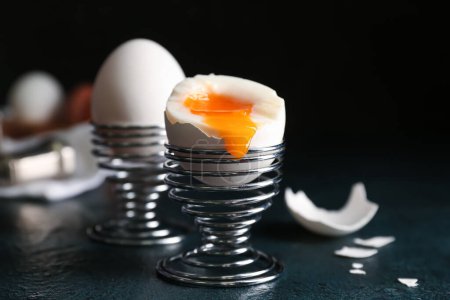Foto de Soportes con huevos cocidos sobre la mesa sobre fondo negro - Imagen libre de derechos