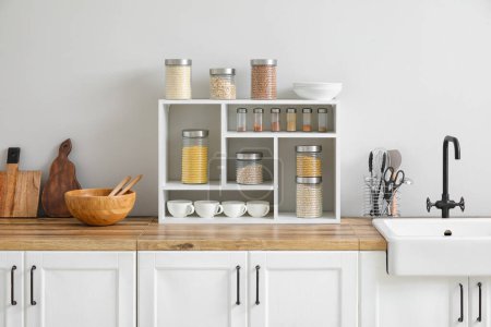 Téléchargez les photos : Pots avec céréales, épices et ustensiles sur le comptoir de cuisine - en image libre de droit