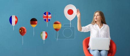 Photo for Young woman with laptop choosing to studying Japanese language on blue background - Royalty Free Image