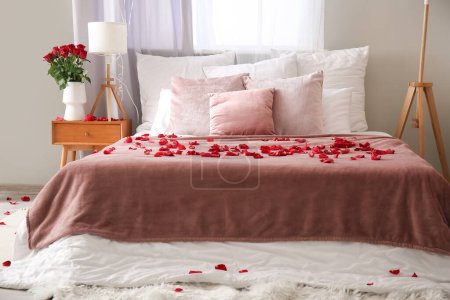 Photo for Interior of light bedroom decorated for Valentine's Day with roses and lamp - Royalty Free Image