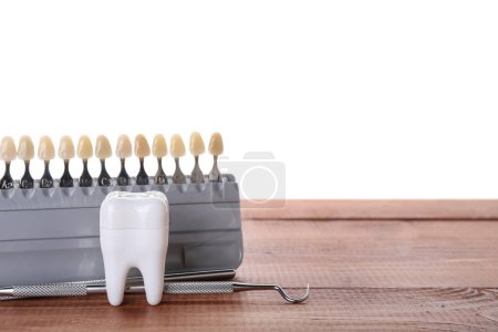 Foto de Muestras de color de los dientes con herramientas dentales sobre la mesa sobre fondo blanco - Imagen libre de derechos