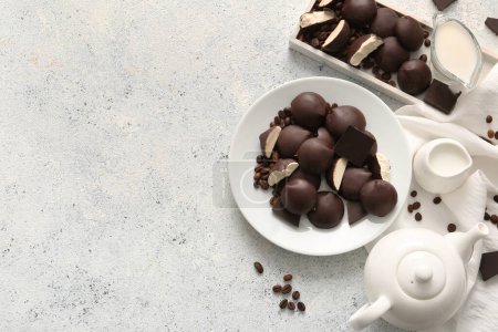 Téléchargez les photos : Assiettes au chocolat sucré bonbons au lait d'oiseau, grains de café, cruches de lait et théière sur fond clair - en image libre de droit