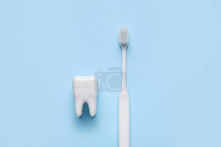 Foto de Diente de plástico con cepillo sobre fondo azul - Imagen libre de derechos