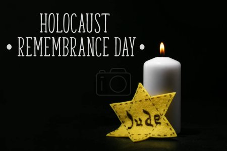 Burning candle and David star on dark background. Holocaust Remembrance Day