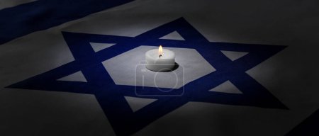 Burning candle on flag of Israel. International Holocaust Remembrance Day