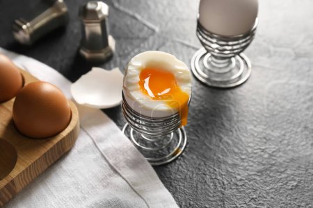 Foto de Holders with soft boiled eggs on black background - Imagen libre de derechos