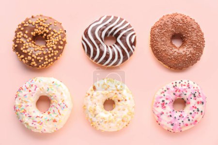 Téléchargez les photos : Assortment of tasty donuts on pink background - en image libre de droit