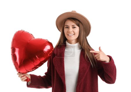Photo for Young woman in hat pointing at balloon for Valentine's Day on white background - Royalty Free Image
