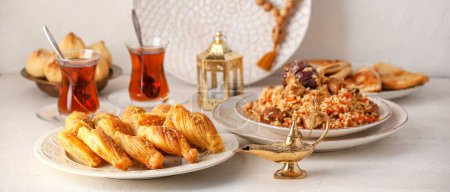 Photo for Traditional Eastern dishes with Aladdin lamps and tea on white table - Royalty Free Image