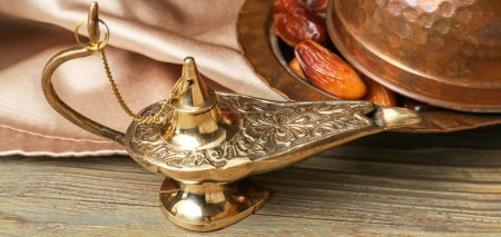 Photo for Aladdin lamp of wishes and dates on wooden table, closeup - Royalty Free Image
