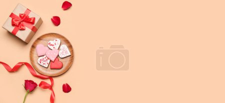 Foto de Composition with tasty heart-shaped cookies, gift box and rose on beige background with space for text. Valentine's Day celebration - Imagen libre de derechos